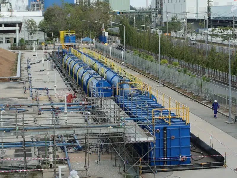 Row of temporary tanks installed alongside a plant road